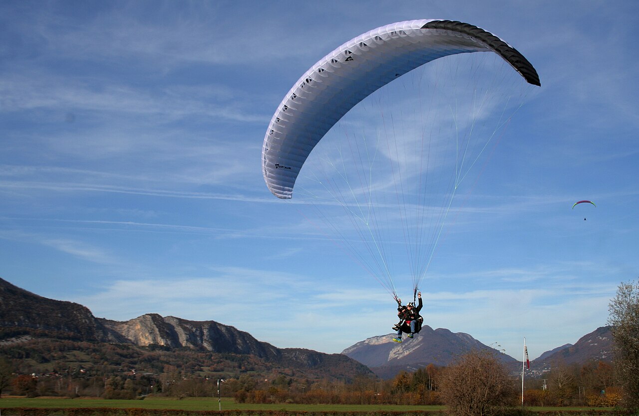 Yann Forget · CC BY-SA 4.0 · https://creativecommons.org/licenses/by-sa/4.0 · https://commons.wikimedia.org/wiki/File:Parapente_biplace_avec_un_enfant,_Haute-Savoie,_France.jpg An actual tandem paraglider flying in Haute-Savoie in the French Alps