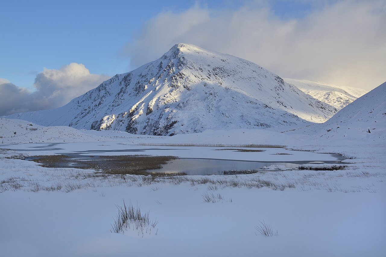 Petersrockypics · CC BY-SA 4.0 · https://creativecommons.org/licenses/by-sa/4.0 · https://commons.wikimedia.org/wiki/File:Pen_Yr_Ole_Wen_-_Flickr_-_Petersrockypics.jpg · Displayed cropped to fit Snow-covered terrain around Pen yr Ole Wen and Llyn Idwal.