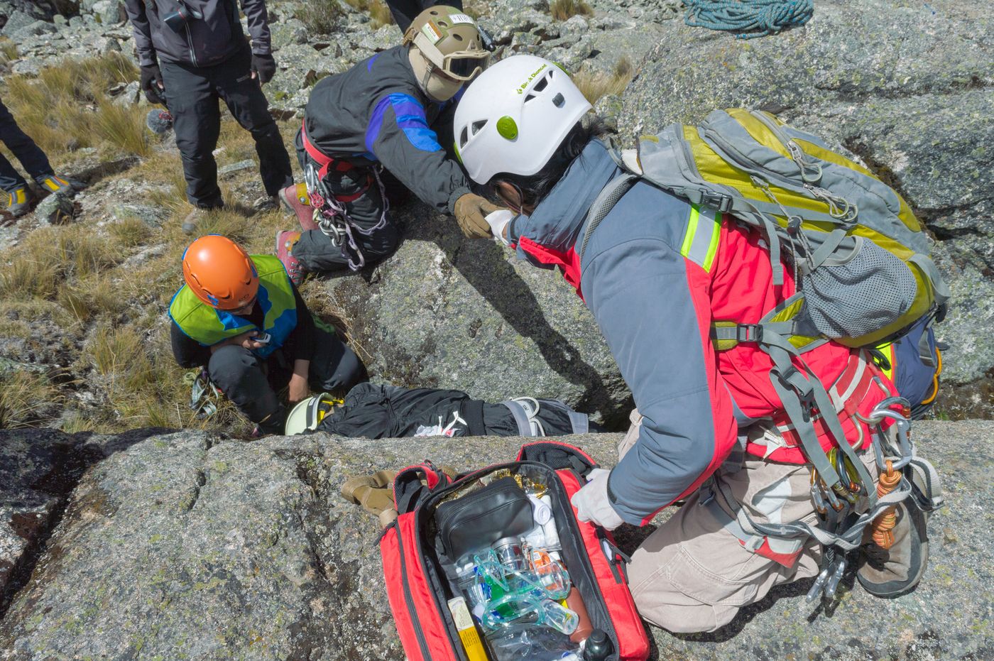 A helmeted mountain rescue team working with specialist equipment