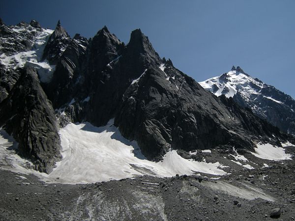 O.Taris · CC BY-SA 3.0 · https://creativecommons.org/licenses/by-sa/3.0 · https://commons.wikimedia.org/wiki/File:DeuxAiglesP%C3%A9lerinsPeigne.jpg · Displayed cropped to fit Granite peaks around the Aiguille du Peigne.