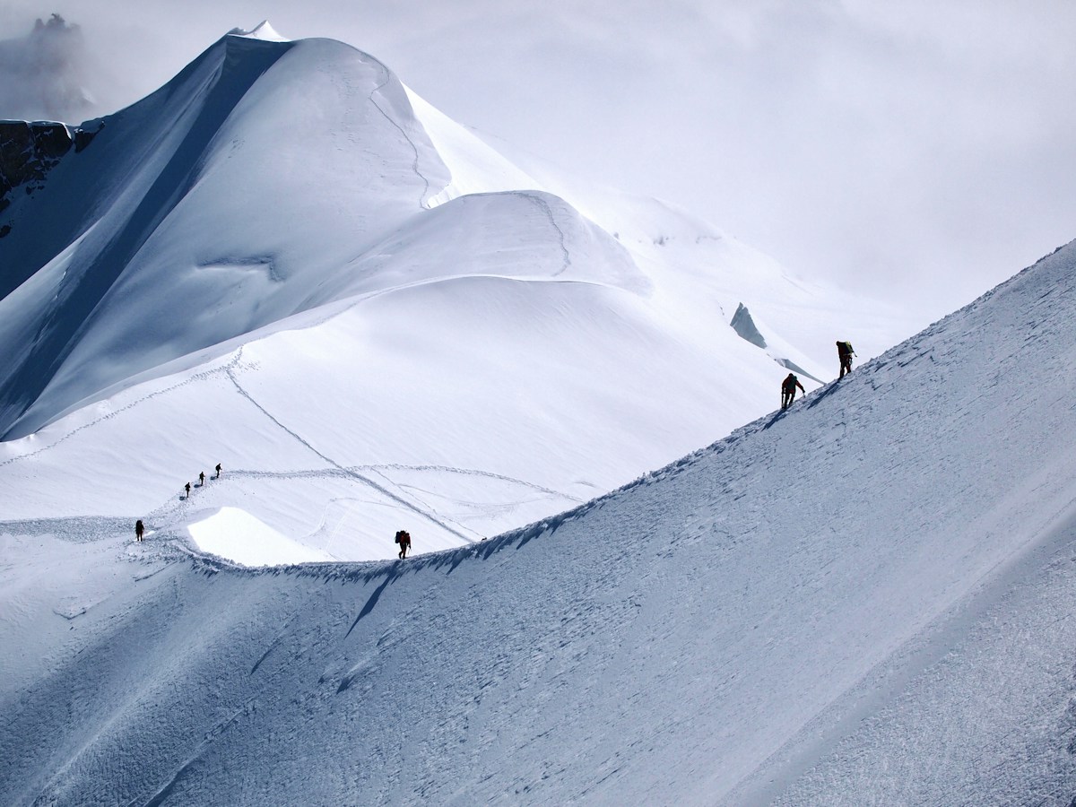 Mountaineers travelling through snow-covered alpine terrain near Aiguille du Midi
