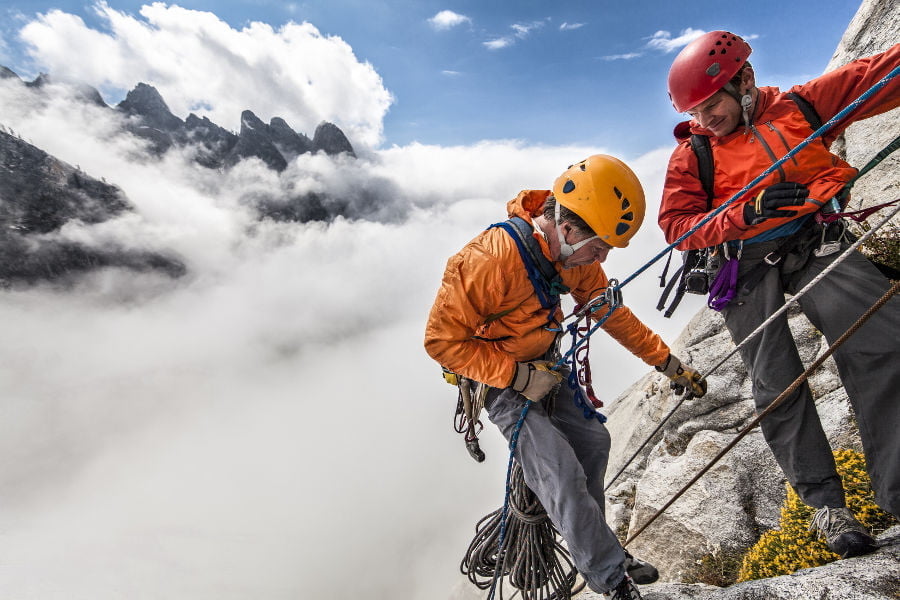 Activity reference photograph supplied for the SOOM website Two helmeted climbers managing ropes on exposed Alpine rock