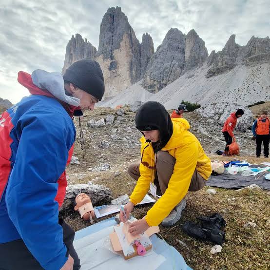 Resuscitation practice using a training manikin below mountain peaks